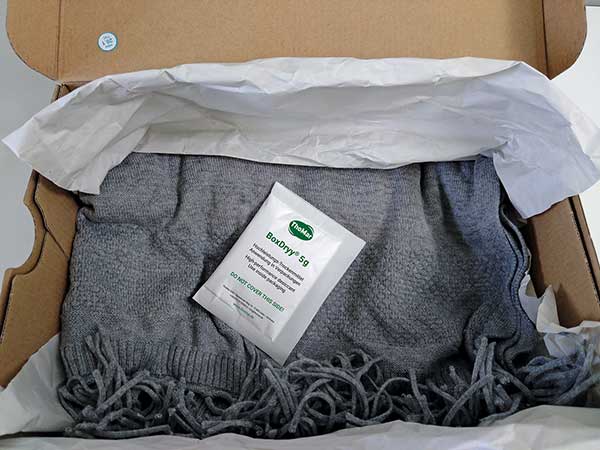 BoxDryy® Beutel innerhalb eines Kartons, in dem ein Schal für den Versand verpackt wird