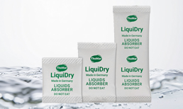 LiquiDry Flüssigkeitsabsorber Sachets vor einer Flüssigkeit